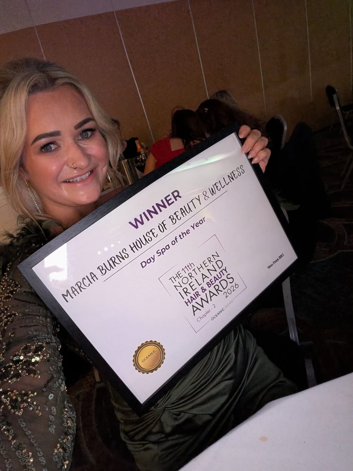 Marcia Burns holding the Day Spa of the Year 2026 winner's certificate at the Northern Ireland Hair & Beauty Awards